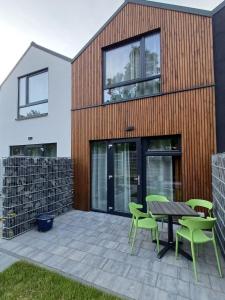 a house with a patio with a table and chairs at Apartamenty być morze in Krynica Morska