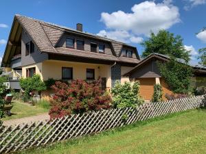 una casa con una valla de madera delante de ella en Auszeit im Gartenweg, en Neuweiler