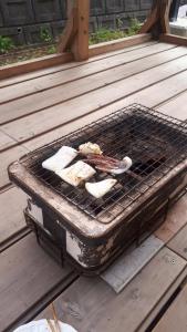 una parrilla con algo de comida encima en ゲストハウスのスタジオ５１, en Sasebo