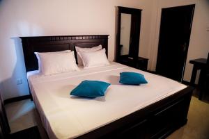 本托塔的住宿－Villana Villa Bentota，一张大床,上面有两个蓝色的枕头