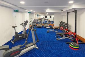 a gym with a row of treadmills and machines at Hotel Cvita in Split