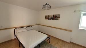 ein kleines Schlafzimmer mit einem kleinen Bett darin in der Unterkunft Charmante maison à Haybes in Haybes