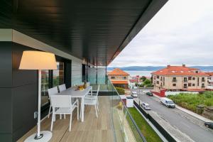 an apartment with a balcony with a table and chairs at CANELAS LUXURY in Portonovo