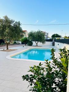 una piscina en un patio con árboles en Apartmani Svemir, en Drage