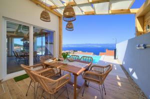 a house with a wooden table and chairs on a balcony at Villa Bella Vista in Vrbnik