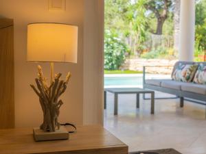 una lámpara en una mesa en una sala de estar con sofá en Villa Syracuse - Chambre privée avec piscine et jardin, en Cogolin