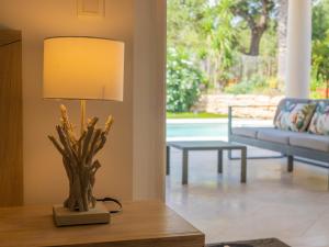 a lamp on a table in a living room with a couch at Villa Syracuse - Chambre privée avec piscine et jardin in Cogolin