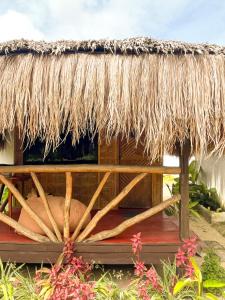 a straw hut with a thatched roof at Siargao Tropic Hostel in General Luna