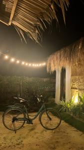 ein Fahrrad, das nachts vor einem Gebäude geparkt ist in der Unterkunft Siargao Tropic Hostel in General Luna