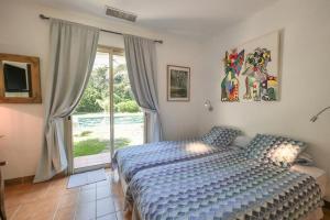 - une chambre avec un lit et une porte coulissante en verre dans l'établissement Villa Alizée B&B, à Saint-Tropez