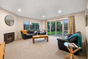 a living room with two couches and a fireplace at Peaceful on Punawai in Taupo