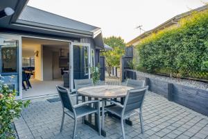 einen Holztisch und Stühle auf einer Terrasse in der Unterkunft Peaceful on Punawai in Taupo