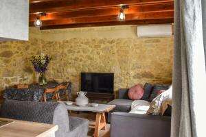 a living room with two couches and a tv at Maria's cottage house in Aïtánia