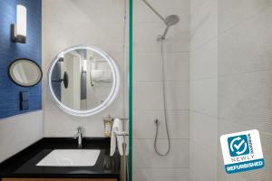 a bathroom with a sink and a shower with a mirror at Danubius Hotel Helia in Budapest