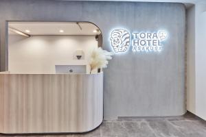 uma área de recepção num átrio do hotel com uma placa em 寅ホテル　浅草　Tora Hotel Asakusa em Tóquio