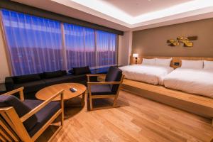 um quarto de hotel com uma cama e um sofá em Spa & Hotel Suishun Matsuiyamate em Quioto