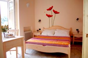 1 dormitorio con 1 cama con flores rojas en la pared en B&B Chez Chantal, en Meta
