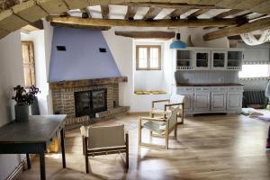 a living room with a fireplace and a table and chairs at La Madriguera de Tomaso in Eraul