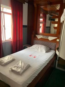 a bed in a small room with a red curtain at Hotel Karisma II in São Bernardo do Campo