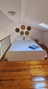 リスボンにあるVila Graçaのウッドフロアの客室の白いベッド1台
