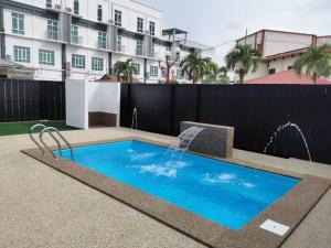 een zwembad met een fontein voor een gebouw bij Shell Out Cenang Beach Resort in Pantai Cenang