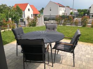 einen Tisch und Stühle mit Sonnenschirm auf einer Terrasse in der Unterkunft SBM Apartman in Balatonfüred