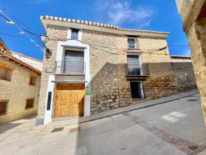 een groot stenen gebouw met een houten deur bij Casa Rural El Americano y disfruta de lo natural in Albentosa