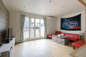 宜蘭市的住宿－乘風之旅溫馨包層華廈每日只接待一組客人最多6人，客厅配有红色沙发和电视