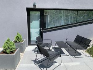- un ensemble de chaises et d'une table sur une terrasse dans l'établissement Chalet - Apartmán Malinô HRABOVO, à Ružomberok