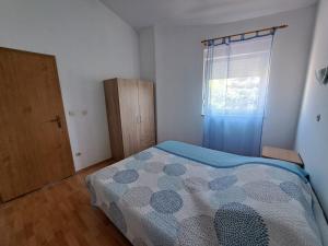 a small bedroom with a bed and a window at Apartments Lucia in Medulin