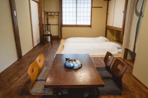 كيو نو يادو سانجن نيننزاكا في كيوتو: غرفة مع طاولة وكراسي وسرير