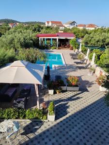 an overhead view of a swimming pool with an umbrella at Villa Stella in Rogoznica
