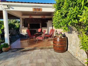 a patio with a table and chairs and a barrel at Villa Stella in Rogoznica
