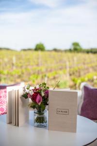 une table avec deux cartes et un vase de fleurs dans l'établissement Domaine de Verchant & Spa - Relais & Châteaux, à Montpellier