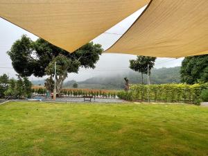 Ban Nong Khwangにあるกระบองแพะの大きな傘の下に公園に立っている人