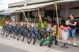 un hombre parado frente a una fila de bicicletas en enJoy Appartements, en Sankt Kanzian