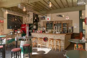 a bar with tables and stools in a restaurant at enJoy Appartements in Sankt Kanzian