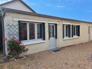 a house with a door and flowers in front of it at Maisonnette Pont de l’Arche in Pont-de-lʼArche