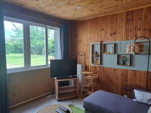 a living room with a television and a couch at Maisonnette Pont de l’Arche in Pont-de-lʼArche