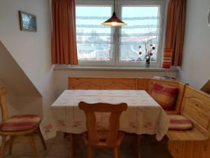 ein Esszimmer mit einem Tisch, 2 Stühlen und einem Fenster in der Unterkunft Ferienwohnung S. Viering in Bernau bei Berlin