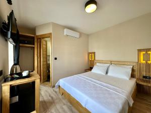 a bedroom with a large bed and a television at Bodrum Konağı in Bodrum City