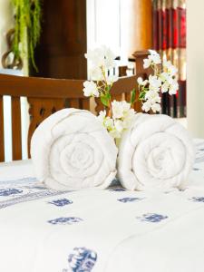 two rolls of towels on a table with flowers at AIRBEST Explore Chiang Rai Hotel in Chiang Rai