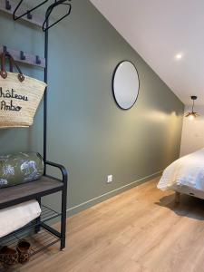 een slaapkamer met een bed en een spiegel aan de muur bij Maison ARBO in Montagne