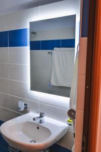 y baño con lavabo blanco y espejo. en Vila Ahmeti, en Sarandë