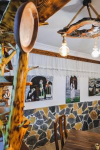 uma sala de jantar com uma mesa e quadros na parede em Vila Ahmeti em Saranda