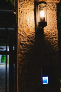 a light on the side of a stone wall at Vila Ahmeti in Sarandë