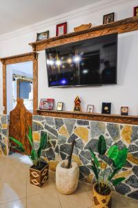 a living room with a tv on a stone wall at Vila Ahmeti in Sarandë