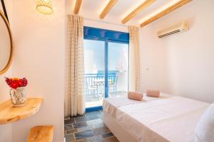 a bedroom with a bed and a view of the ocean at Junior Traditional Suite in Archangelos