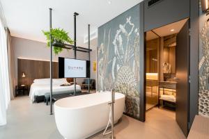 a bathroom with a bath tub and a bedroom at DUPARC Contemporary Suites in Turin