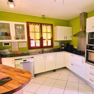 cocina con armarios blancos y mesa de madera en Atlantic Gites, en Capesterre-Belle-Eau